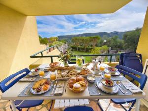a table with breakfast food on a balcony at Rivierarent Il Giardino Del Navigatore in Finale Ligure +17 photos