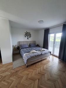 a bedroom with a large bed with blue pillows at KUĆA za odmor 128 in Plešivica