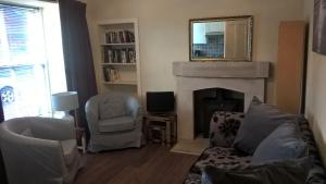 a living room with a fireplace and a mirror at Bankfoot Inn in Bankfoot