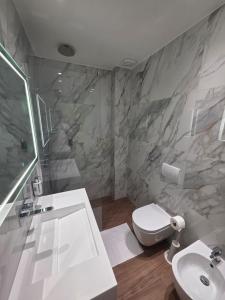 a bathroom with a white toilet and a sink at Haris Hotel & Suites in Vlorë +58 photos