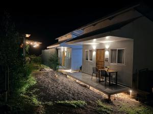 a small house at night with a table and chairs at Villa Carpintera in Puntarenas