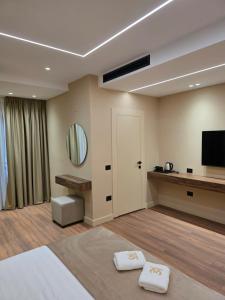 a room with a bed and a flat screen tv at Haris Hotel & Suites in Vlorë