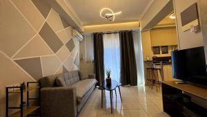 a living room with a couch and a tv and a kitchen at GiAngels in Chania