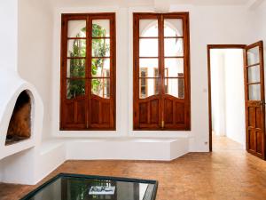 a room with two wooden doors and a glass table at JIBARI, riad luminoso con patio en la medina de Asilah in Asilah