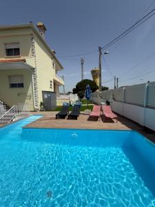 a swimming pool in front of a house at Moradia com escada, Jardim e piscina, 3Kms Praia in Almada