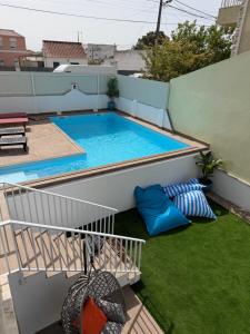 a small swimming pool on a balcony with grass at Moradia com escada, Jardim e piscina, 3Kms Praia in Almada
