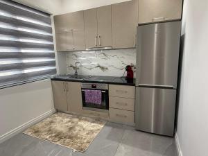 a kitchen with a stainless steel refrigerator and cabinets at Holliday Villa in Tirana