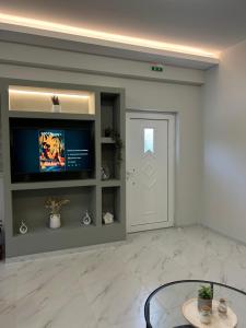 a living room with a television and a door at Garden House in Kalamata