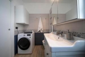 a bathroom with a washing machine and a sink at Caliante in Piraino