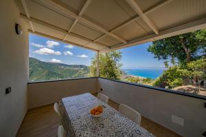 a dining room with a table and a view of the ocean at Caliante in Piraino