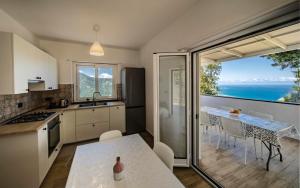 a kitchen with a table and a view of the ocean at Caliante in Piraino