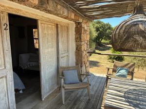 a porch with two chairs and a swing at Chambre bergerie privée in Sartène