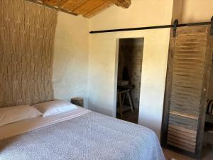 a bedroom with a bed and a wooden door at Chambre bergerie privée in Sartène