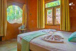 a bedroom with a bed with two towels on it at Bathle Eco Resort in Mawanella