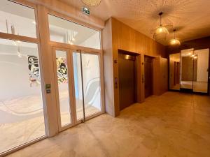 an empty room with glass doors and a hallway at Le Royal VIBES in Cap d'Agde