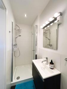 a white bathroom with a sink and a shower at Moderne Ferienwohnung Deichstrasse in Hennef