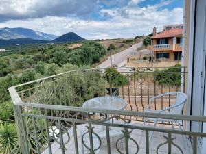 a balcony with two chairs and a view of a road at Irini's Villa in Argostoli