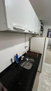 a kitchen counter with a sink and a refrigerator at Apartamento Completo No Centro de Taboão da Serra in Taboão da Serra +12 photos