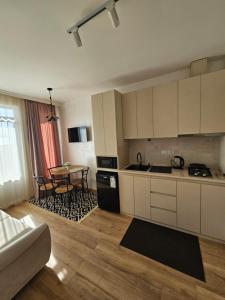 a kitchen with white cabinets and a table with chairs at Guesthouse Maka in Ureki
