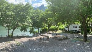 a camper van parked next to a body of water at Natura Koman in Koman