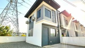 a house with a green door and a electricity tower at Phirst Park Homes Baliwag in Baliuag