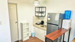 a small kitchen with a refrigerator and a sink at Phirst Park Homes Baliwag in Baliuag