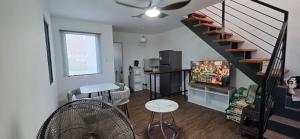 a living room with a staircase and a television at Phirst Park Homes Baliwag in Baliuag