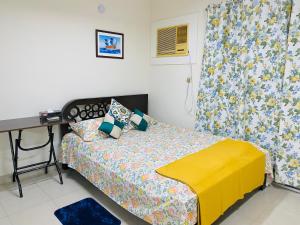 ein Schlafzimmer mit Bett, Schreibtisch und Vorhängen in der Unterkunft ADD Eden in Dhaka