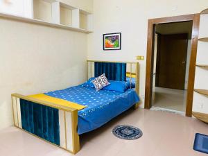 ein Schlafzimmer mit einem Bett mit blauer Bettdecke in der Unterkunft ADD Eden in Dhaka + 1 Foto