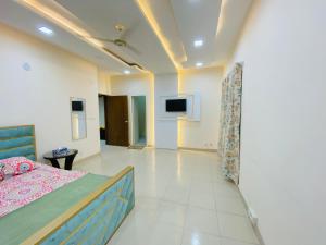 ein Schlafzimmer mit einem Bett und einem Fernseher an der Wand in der Unterkunft ADD Eden in Dhaka