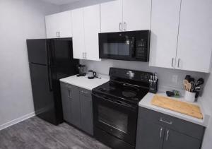 a kitchen with black appliances and white cabinets at Olive Oasis in Des Moines