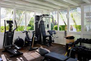 a gym with treadmills and ellipticals in a room with windows at California Park Hotel in Forte dei Marmi
