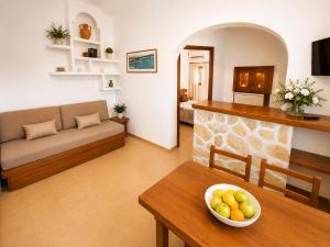 a living room with a couch and a bowl of fruit on a table at Can Joan Robert des Mestre in Es Caló