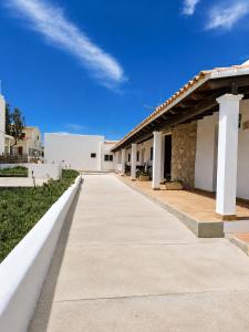 a walkway outside of a building with a blue sky at Can Joan Robert des Mestre in Es Caló