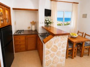a kitchen with a sink and a table with a window at Can Joan Robert des Mestre in Es Caló