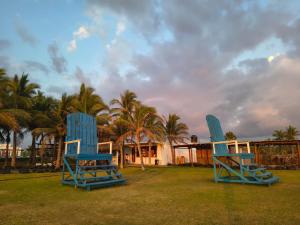 two blue chairs sitting on the grass in front of a house at Casa Acapulco de mis amores Diamante in Acapulco