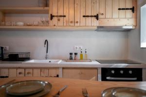 a kitchen with wooden cabinets and a sink at Yiayia's House in Votsi