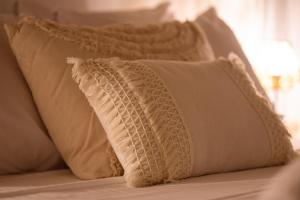 a pile of white pillows on a bed at Yiayia's House in Votsi +16 photos