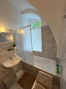 a bathroom with a sink and a bath tub with a window at Gipfelglück Sebnitz Apartment in Sebnitz +14 photos