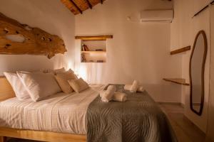 a bedroom with a large bed with white sheets at Yiayia's House in Votsi
