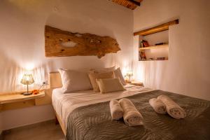 a bedroom with a bed with towels on it at Yiayia's House in Votsi