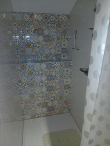 a bathroom with a tiled wall with a shower at Gite de Labarraque in Monbahus