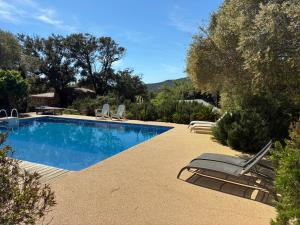 a swimming pool with two lounge chairs next to it at Chambre bergerie privée in Sartène