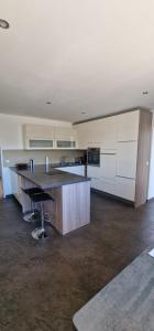 a large kitchen with white cabinets and a large island at Time Out 13 in Ohlsdorf