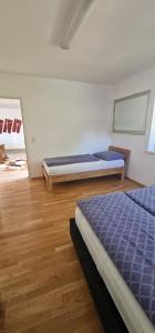 a bedroom with two beds and a wooden floor at Time Out 13 in Ohlsdorf