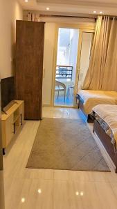 a bedroom with two beds and a tv and a window at Avenue Alhambra princess resort in Hurghada