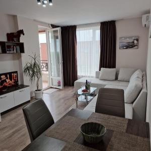 a living room with a couch and a table at Ferano Beach Apartments in Nesebar