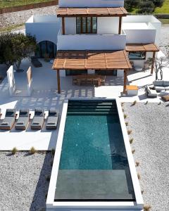 a swimming pool with a table and chairs next to a house at the shelter - a milos project in Adamantas