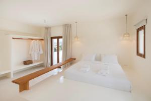 a white bedroom with a large bed and a window at the shelter - a milos project in Adamantas