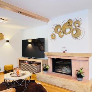 a living room with a fireplace and a tv at Chalet Mountain Lodge in Kandersteg